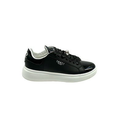 Sneakers in pelle nera liscia con lacci ed accessorio geometrico sui lacci